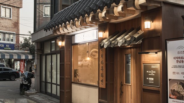 A traditional Korean restaurant with a wooden facade, a tiled roof, and a signboard with Korean text. - Futon Guesthouse (Seoul)