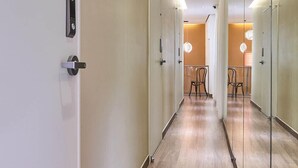 A modern hallway with glass doors, wooden flooring, and recessed lighting. - Futon Guesthouse (Seoul)