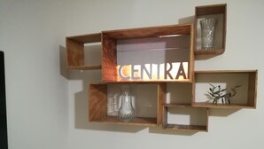 A wall with wooden shelves containing various items including a glass vase, a decorative metal piece, and a sign with the word 'CENTRA'. - Central Station House Riccardo (Catania)