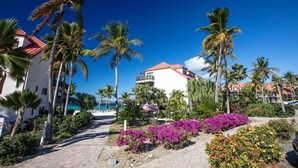 A resort with a white building, palm trees, and a clear blue sky. - Sapphire Beach Resort Rental (St Thomas)