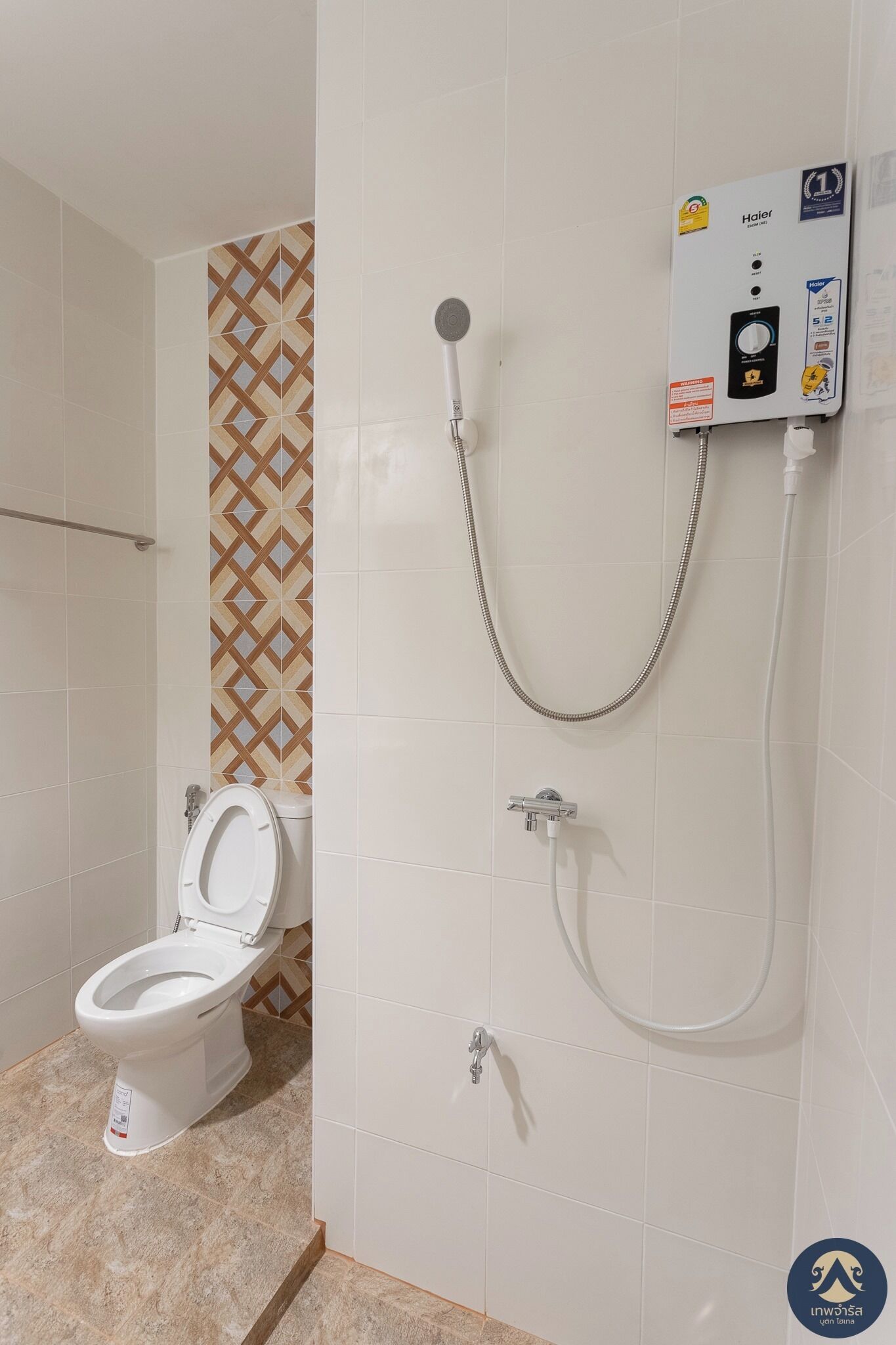 A bathroom with a toilet, a shower, and a wall-mounted control panel.
