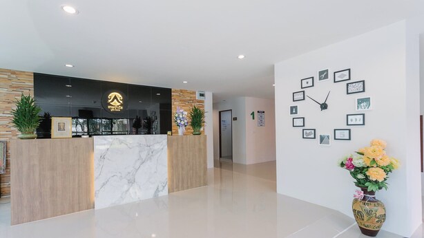 Un espace d’accueil moderne avec un comptoir en marbre, un lambris en bois et une horloge au mur.