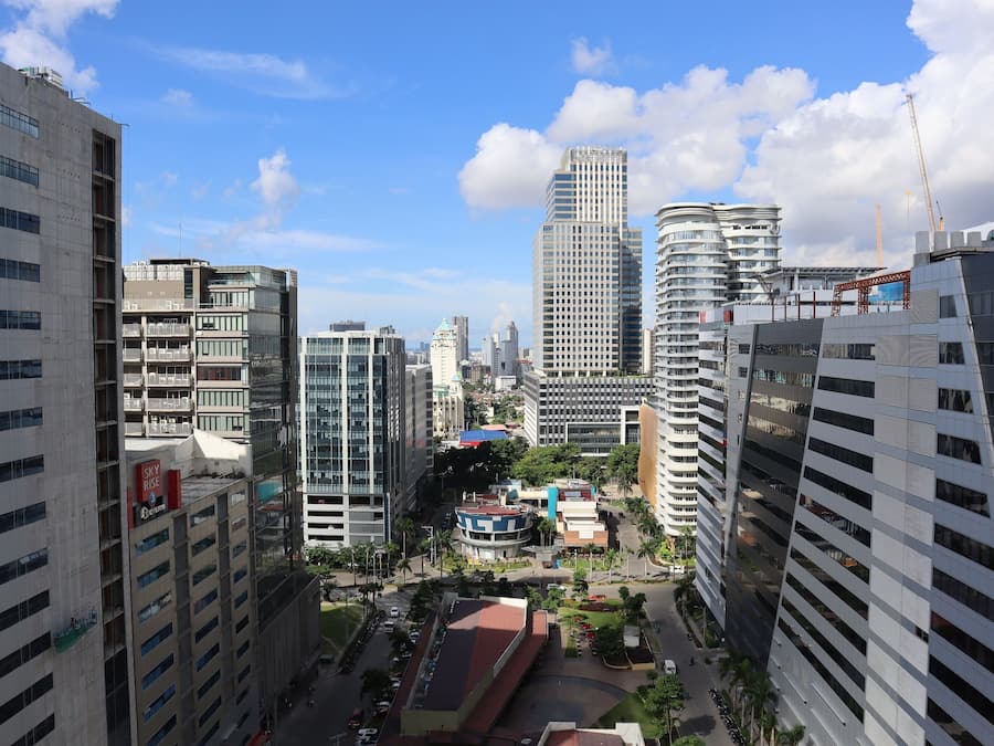 A cityscape with modern high-rise buildings, a central roundabout, and a mix of commercial and residential structures.