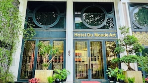 Hotel Du Monde Art with a classic facade, large glass doors, and a prominent entrance with steps.