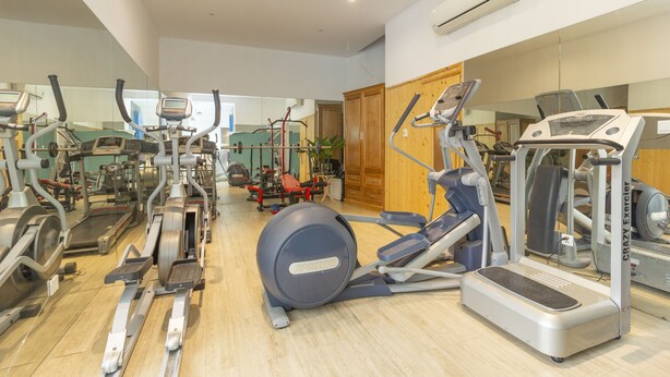 A gym with various exercise equipment, including treadmills, elliptical machines, and a stationary bike. - The Art - Sunshine Apartment (Ho Chi Minh City)