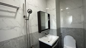 Superior vierpersoonskamer | Badkamer | Een douche, gratis toiletartikelen, een bidet, handdoeken