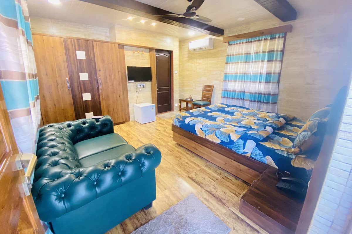 A room with a bed, a sofa, a desk, and a wardrobe.