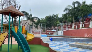 Un parque infantil con tobogán, balancín y estructuras para escalar.