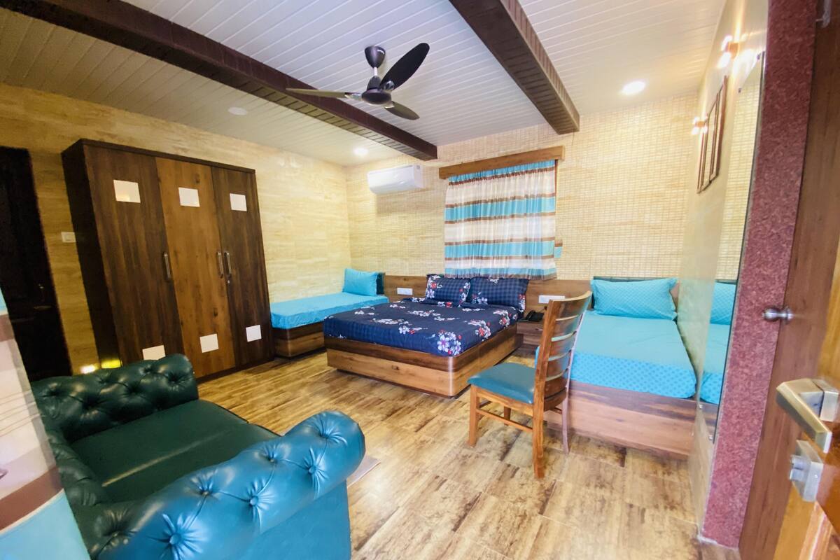A room with a bed, a sofa, a chair, and a wardrobe.