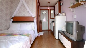 A bedroom with a bed, a television, and a refrigerator. - Badasol Fragrance Pension (Taean)