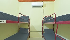 A dormitory room with bunk beds, an air conditioning unit, and a visible door. - Hotel O Sohotel (Pelabuhan Klang)