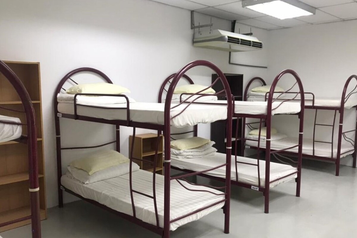 Schlafstellen im Stockbett in einem Schlafraum mit Deckenventilator und Fernseher.