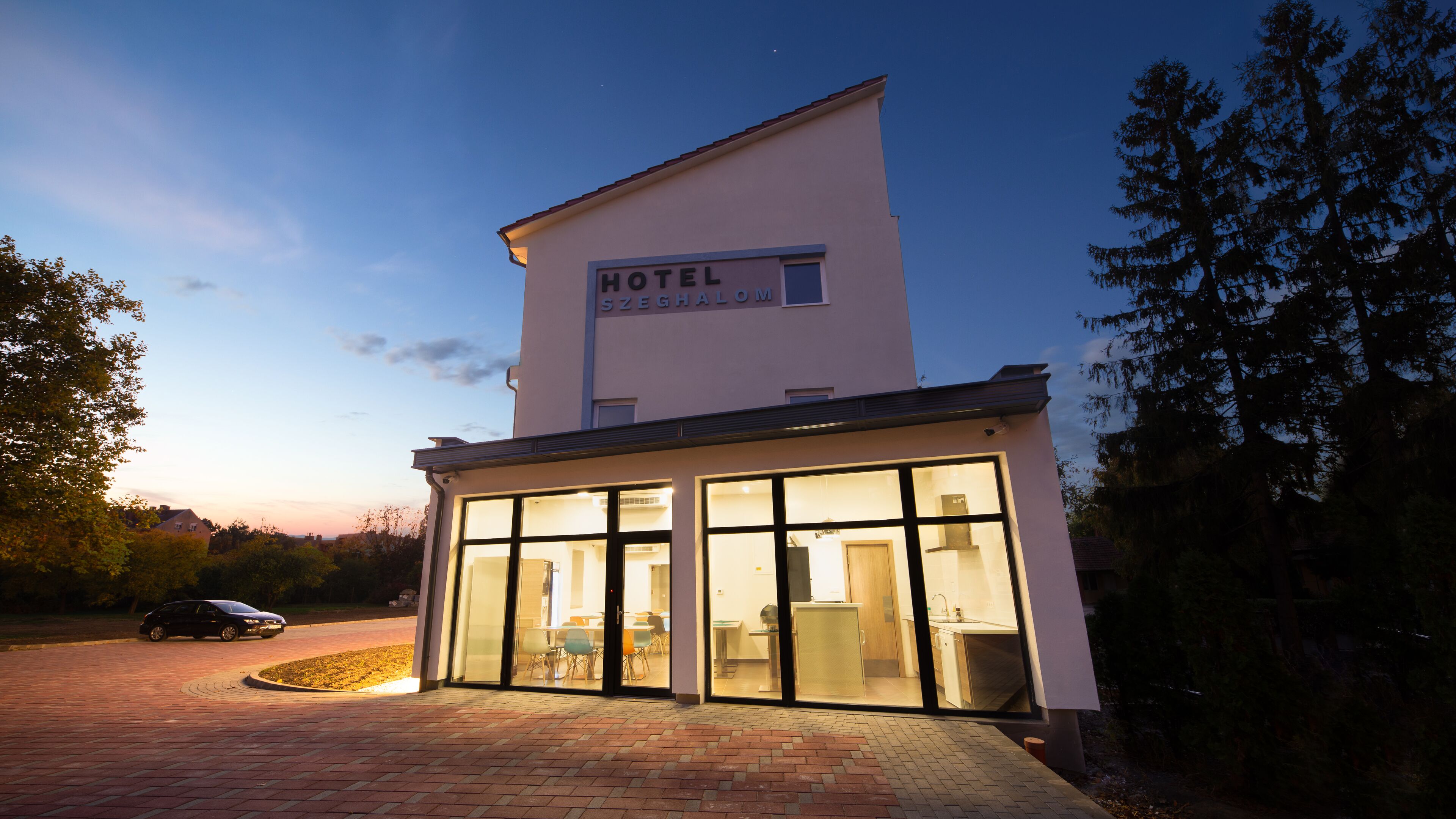 Un hotel con un letrero que dice "HOTEL SZEGHALOM" en la parte superior.