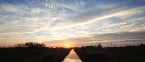 Un canal reflejando el atardecer bajo un cielo despejado.