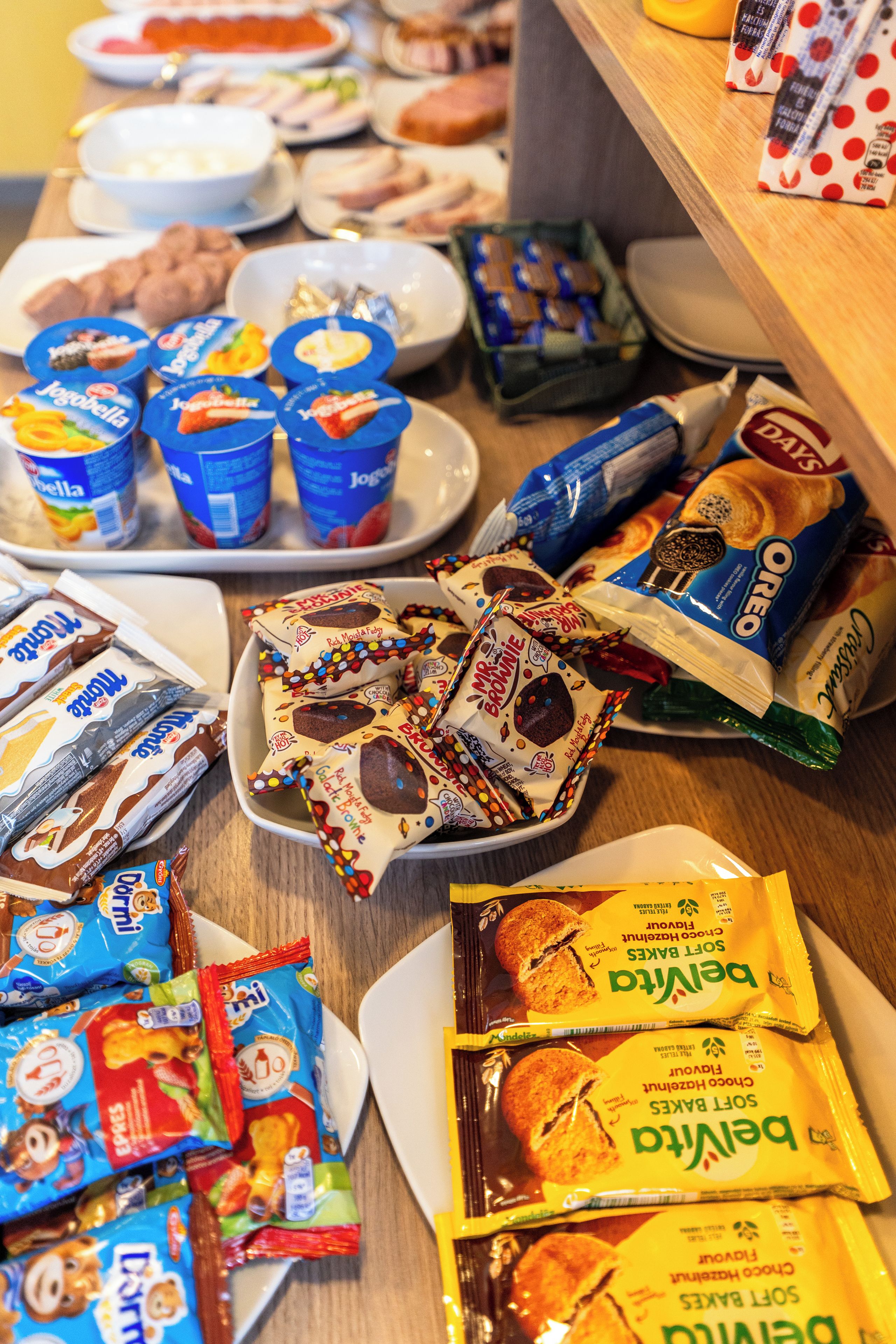 Diversas opciones de bocadillos y postres envasados sobre una mesa.
