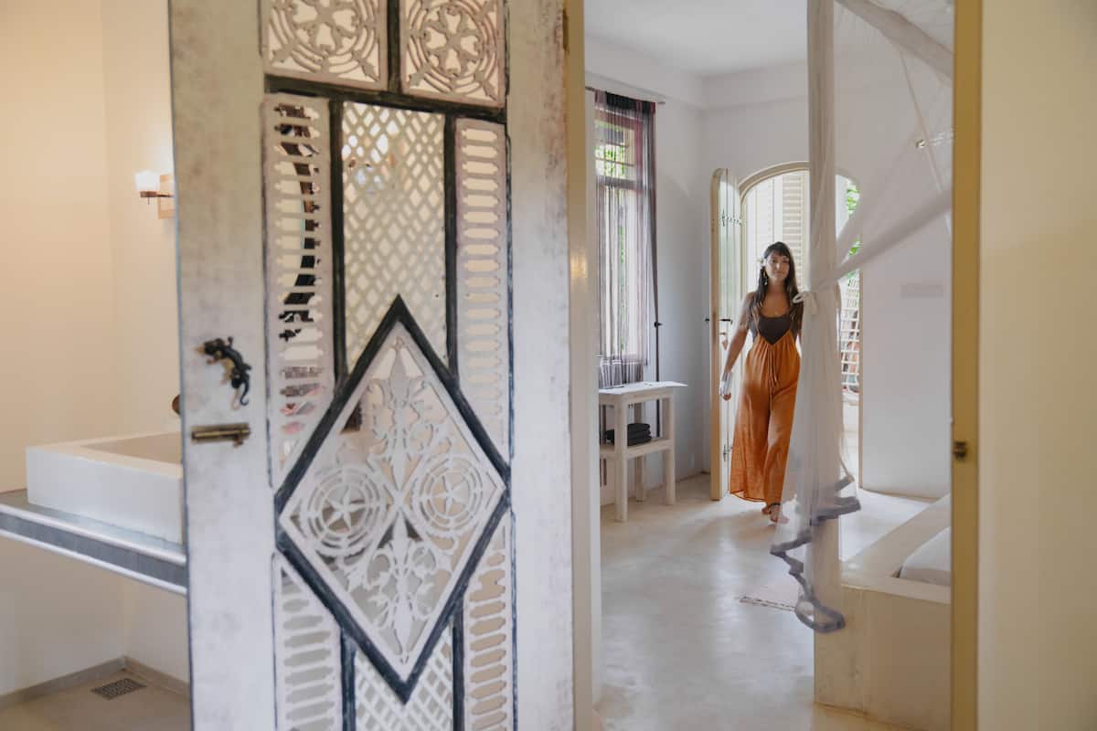 Un escalier menant à un palier surmonté d’une porte blanche décorative.
