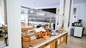 Uma área de buffet de café da manhã com cestas de vime, pão e diversos alimentos.