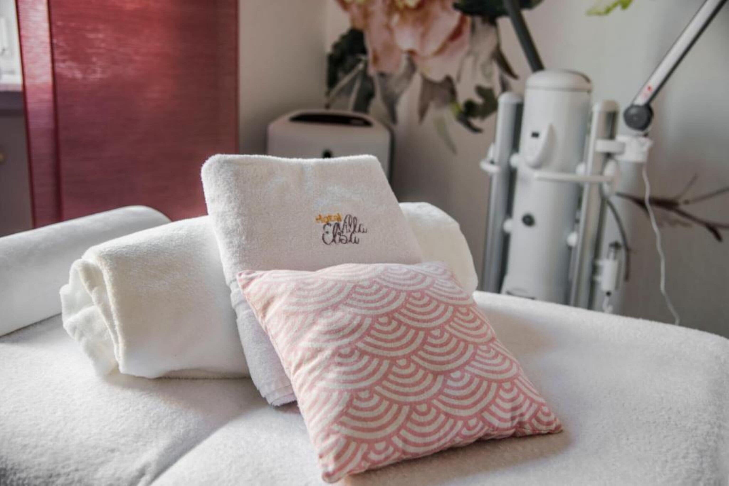 A neatly arranged bathroom with towels and a decorative pillow.