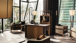 A modern interior with a central wooden island, seating, and a view through large windows. - The Clan Hotel Singapore by Far East Hospitality (Singapore)