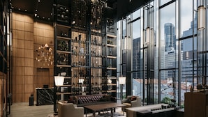 A modern interior with a large window, a seating area, and a bookshelf.