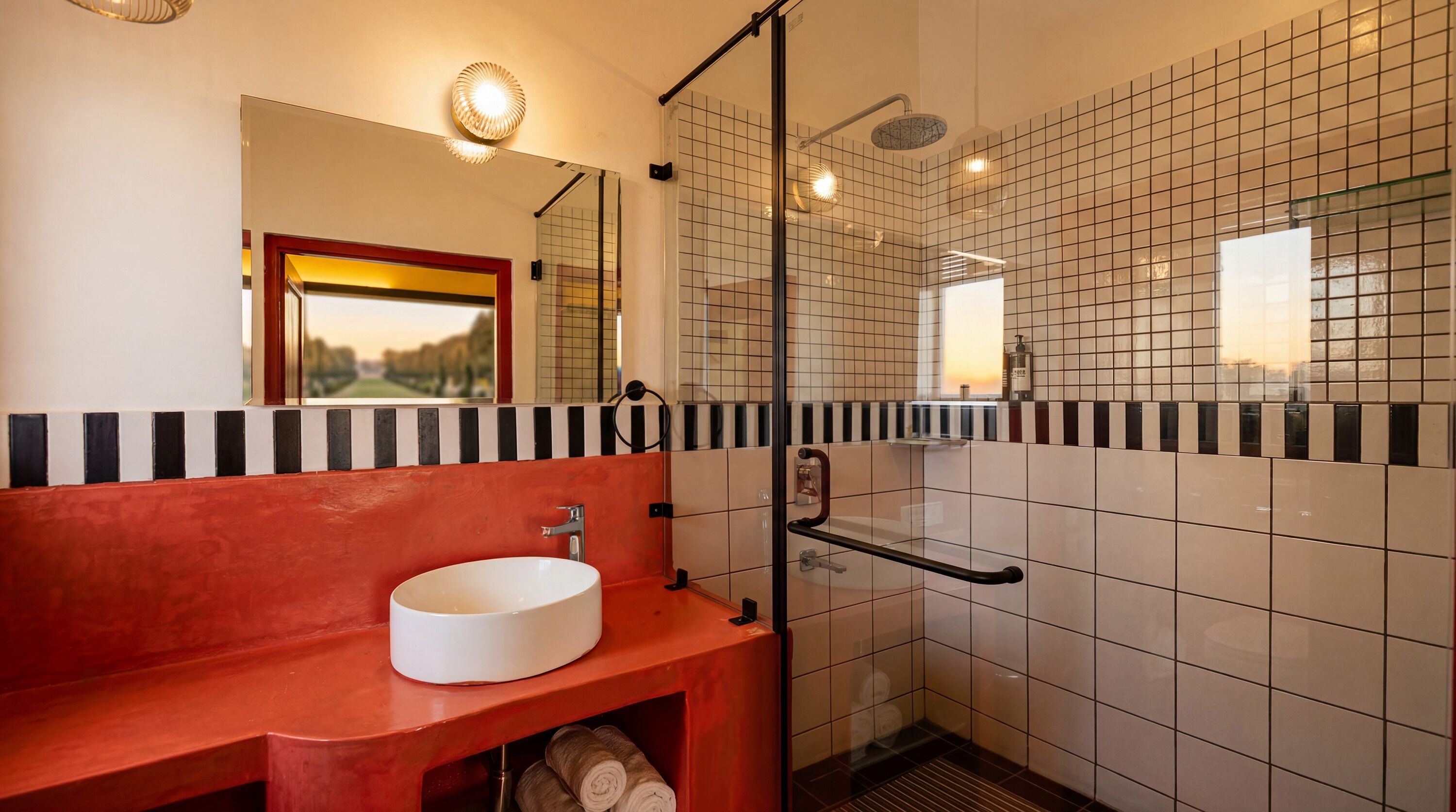 A modern bathroom with a glass shower enclosure, a white sink, and a red vanity.