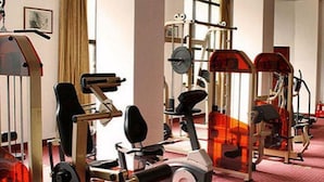 Une salle de sport équipée de divers appareils d’exercice, notamment des tapis de course et des appareils de musculation.