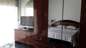 A bedroom with a bed, a TV on a dresser, and a wardrobe. - Charming 3 bedroom apartment centrally located (Cullera)