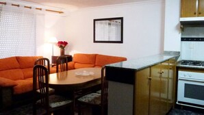 A compact kitchen with a dining table, chairs, and a sofa. - Charming 3 bedroom apartment centrally located (Cullera)