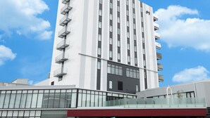 A modern hotel building with a white facade, multiple balconies, and large windows. - Hotel Maruya Grande (Minamisoma)