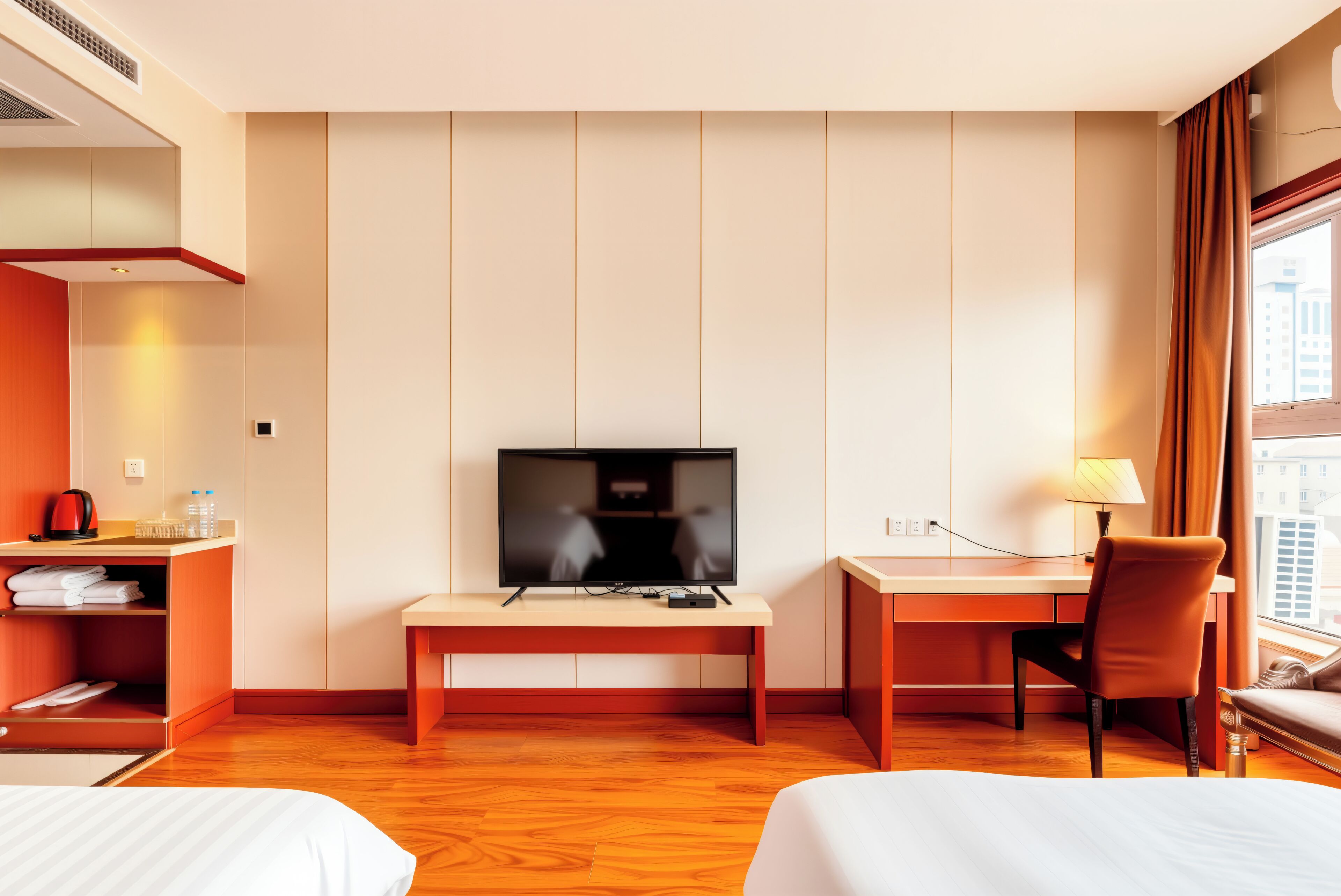 A hotel room with a bed, a desk with a chair, a television, and a window with curtains.