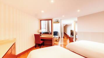 Una habitación de hotel con cama, escritorio, silla y espejo.