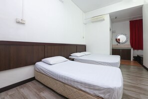 Habitación de hotel con dos camas, un cabecero de madera, un espejo y una cortina roja.