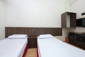 A room with two single beds, a wooden headboard, a small wooden nightstand with drawers, a cabinet with glass doors, and a mounted television. - OYO 89755 D&d Budget Inn (Kota Bharu)