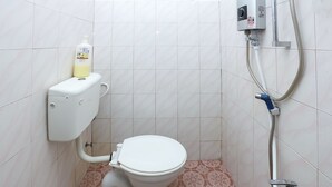 A bathroom with a toilet, a hand sanitizer dispenser, and a shower system. - OYO 89755 D&d Budget Inn (Kota Bharu)
