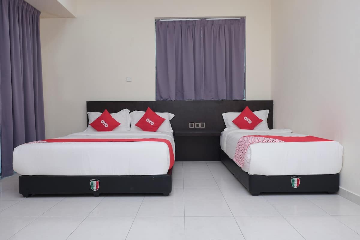 Habitación de hotel con dos camas, cada una con cabecera negra y un logo en la solapa.