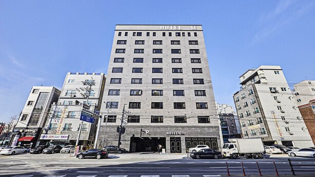 A tall, rectangular hotel building with a flat roof and a sign reading "HOTEL".