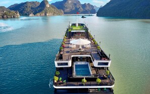 Un crucero con piscina, zona de estar al aire libre y comedor.
