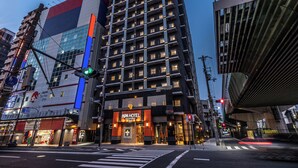 A multi-story building with a prominent APA HOTEL sign, a modern architectural design, and a crosswalk in the foreground. - APA Hotel Nambaminami Ebisucho Eki Shinsekai (Osaka)