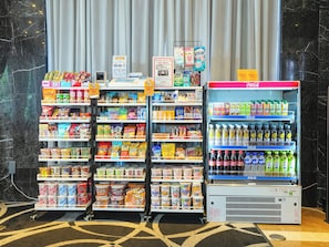 A vending machine stocked with beverages and a refrigerated display of snacks and drinks.