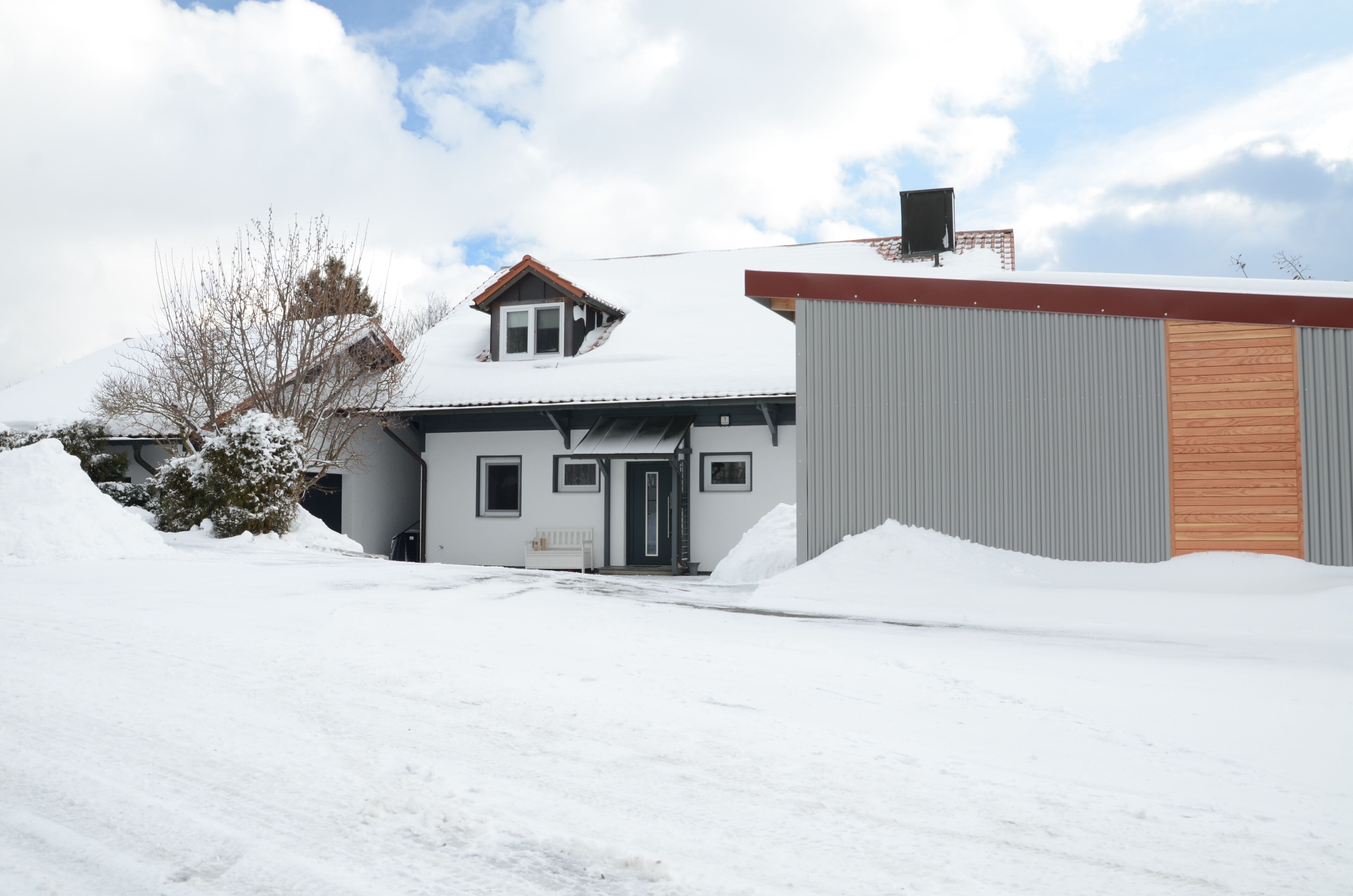 A residential building with a sloped roof, a garage, and a small porch.