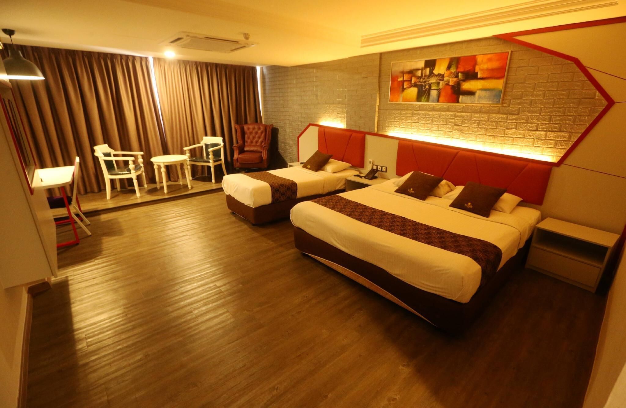 A hotel room with two beds, a desk, chairs, and a large abstract painting on the wall.