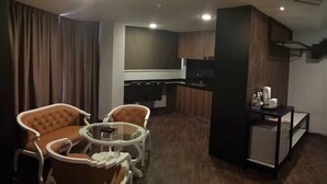 A compact hotel room with a dining area, a small kitchenette, and a TV mounted on the wall. - Golden Nasmir Hotel (Perai)
