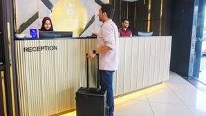 A reception desk with a 'RECEPTION' sign, a logo, and a 'VISA' sign indicating a payment terminal. - Golden Nasmir Hotel (Perai)