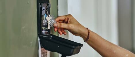 A hand inserting a key into a keycard reader on a door.