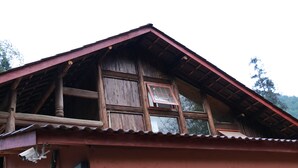 A rustic wooden building with a peaked roof and a visible window. - Qing Dynasty House (Leshan)