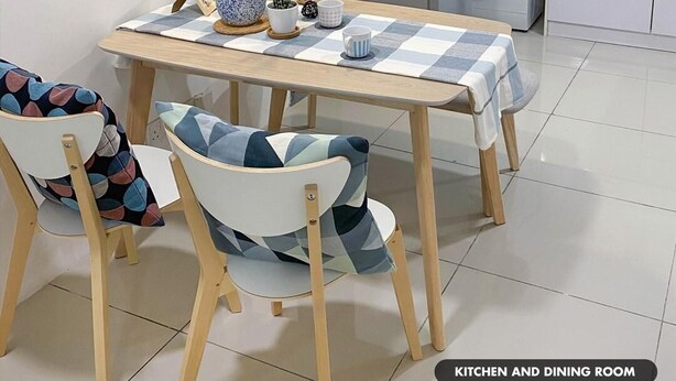 Cocina y comedor con una mesa, sillas, lavadora y fregadero.