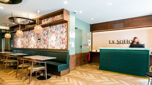 A restaurant interior with wooden flooring, green booths, and hanging pendant lights. - Lx SoHo Boutique Hotel by RIDAN Hotels (Lisbon)