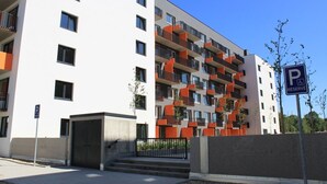 A modern apartment building with a parking sign indicating reserved parking.