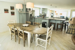 Una cocina amplia con una isla central, una mesa de comedor de madera y sillas.