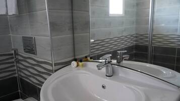 Un baño con un lavabo blanco, un espejo y una pared con estampado de cebra.